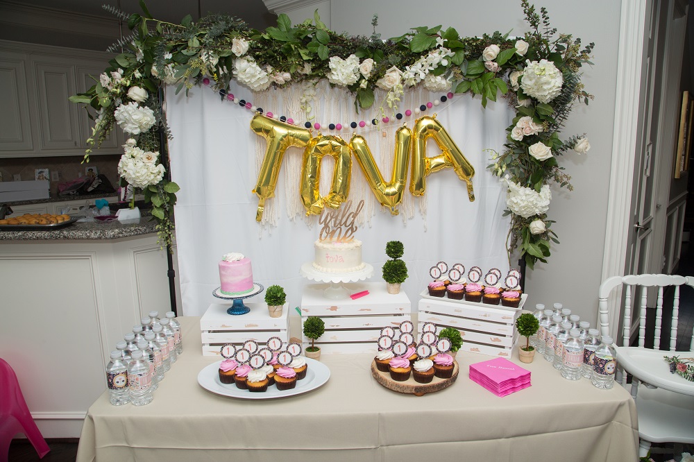 Tova's first birthday party floral backdrop and dessert table