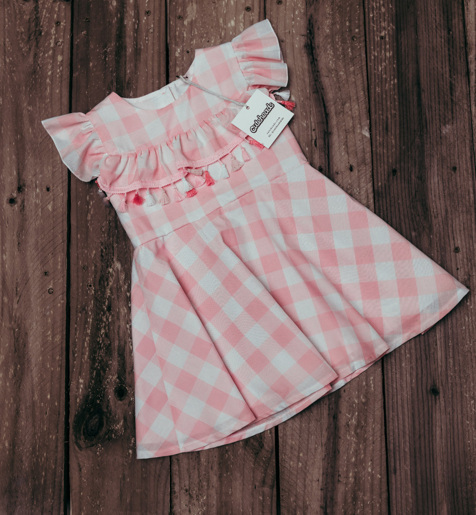 Introducing a subscription box for girls that your daughter will love. Get a surprise dress in the mail every month! Learn more at cuteheads.com. // The cuteheads pink buffalo plaid tassel dress, only available in the Mystery Box!