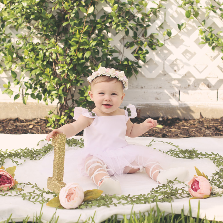 Lilyana's first birthday photoshoot and cake smash, featuring tutu romper with pompom trim from cuteheads